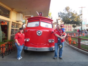 Patrick and his family standing by a red truck