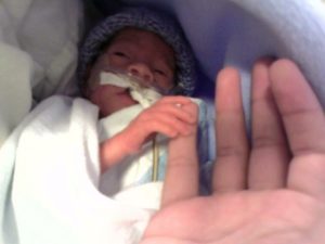 Newborn Jonathan holding onto his mother's hand