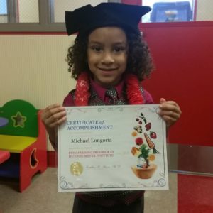 Michael holding his certificate after graduating from the feeding clinic program