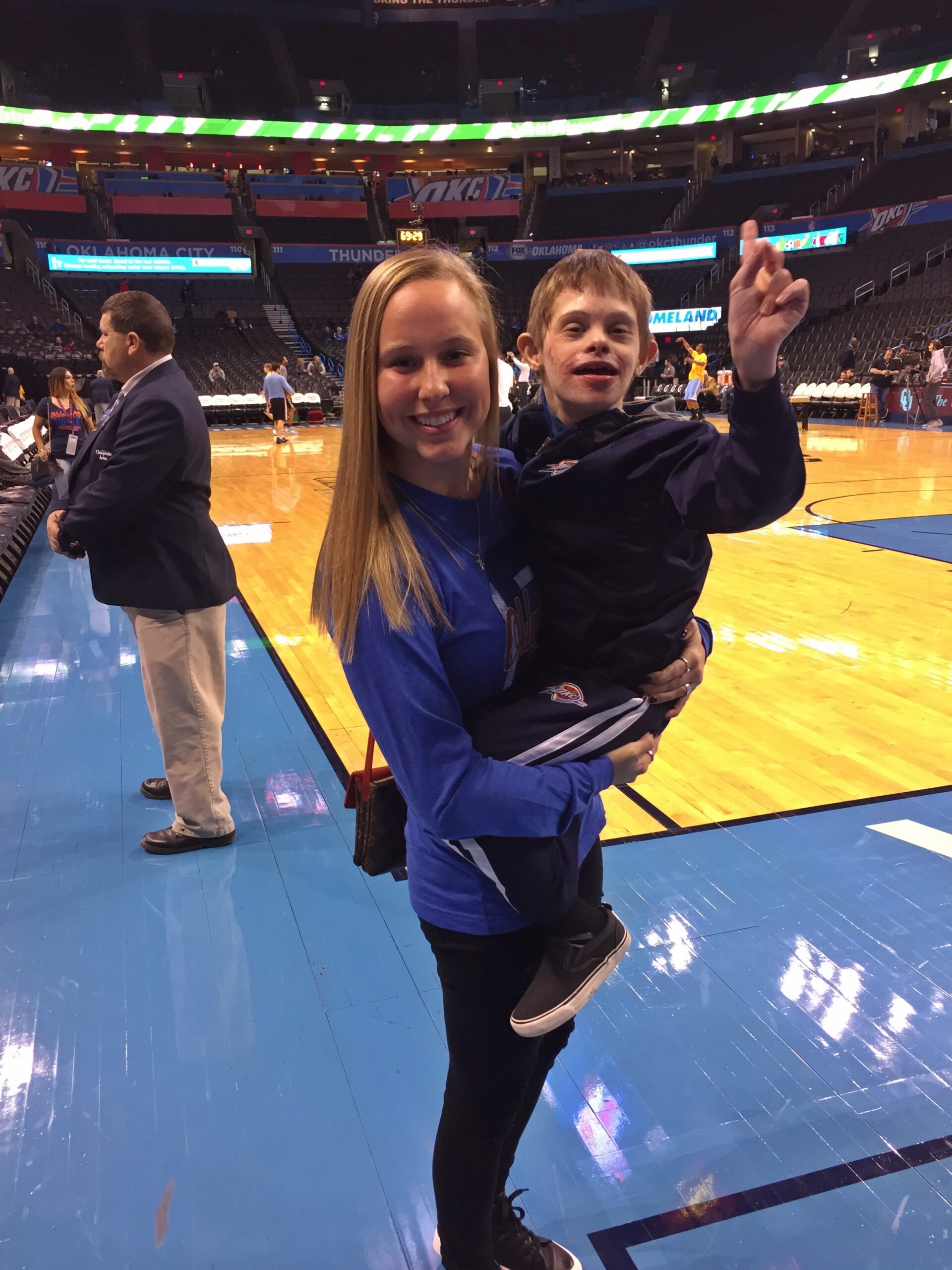 Mackenzie and Clayton standing on the court at the Oklahoma City Thunder game