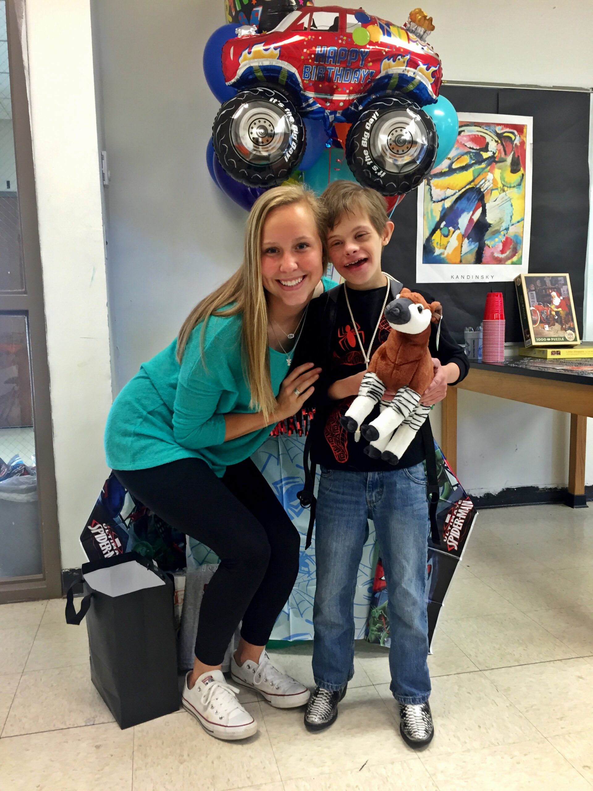 Mackenzie and Clayton standing together, Clayton holding a stuffed okapi