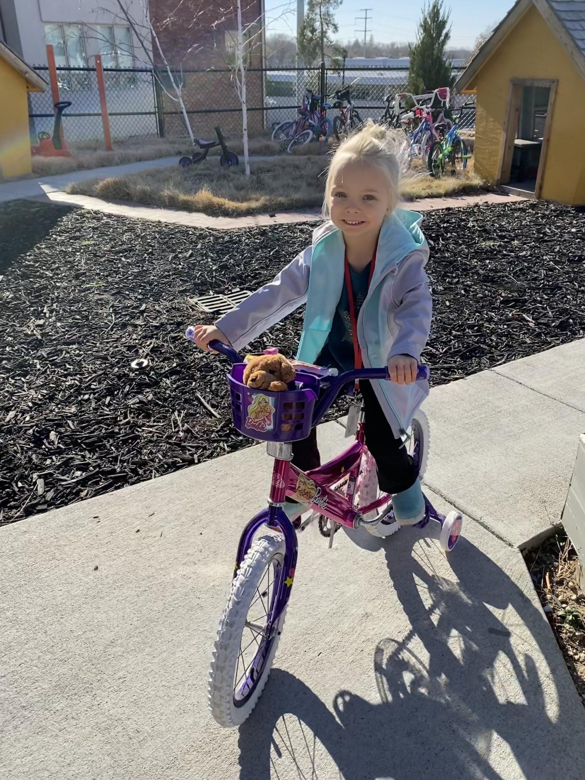 Remi rides a bike around the Ronald McDonald House backyard