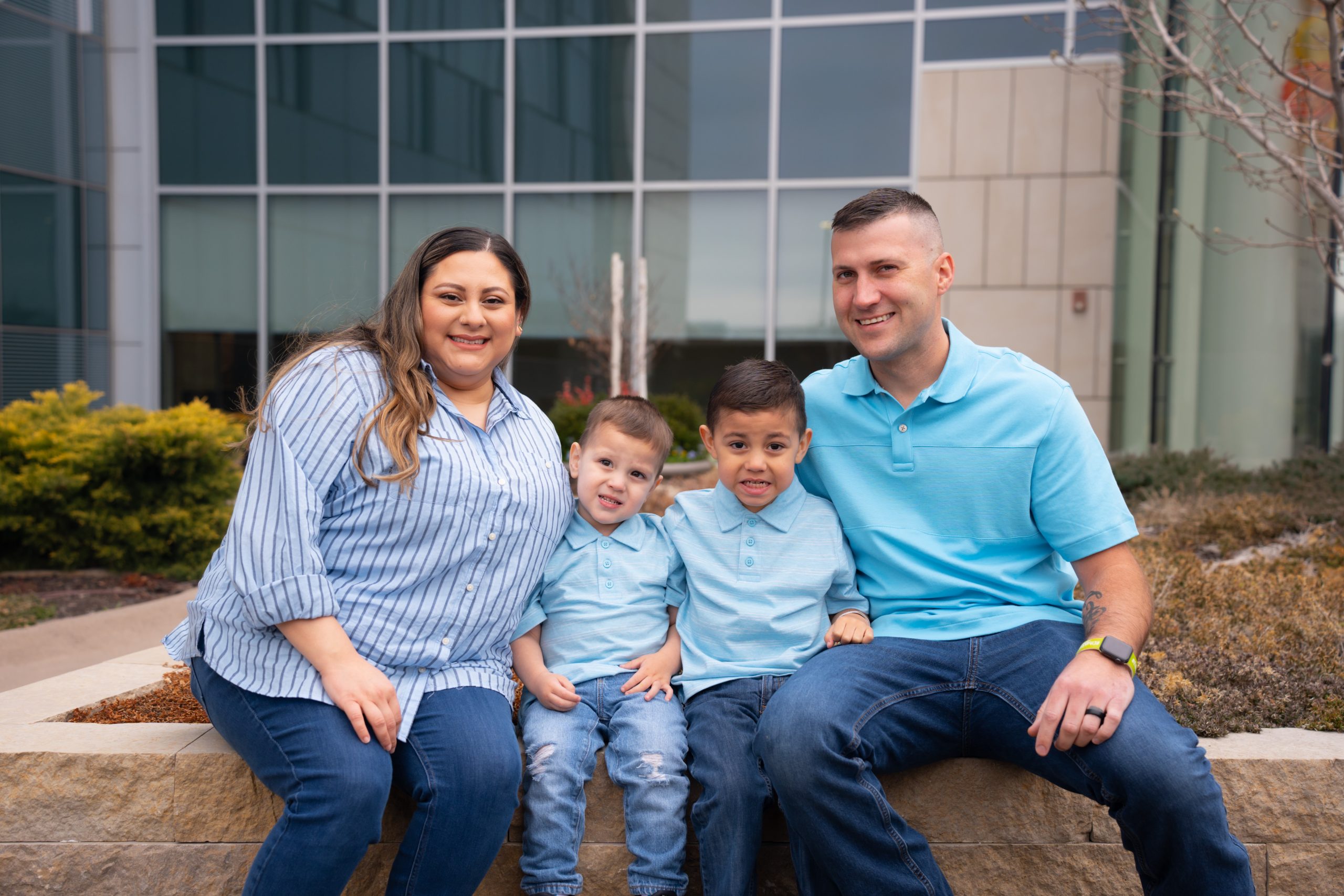 The Griggs family sits on a bench outside the hospital for their photo session