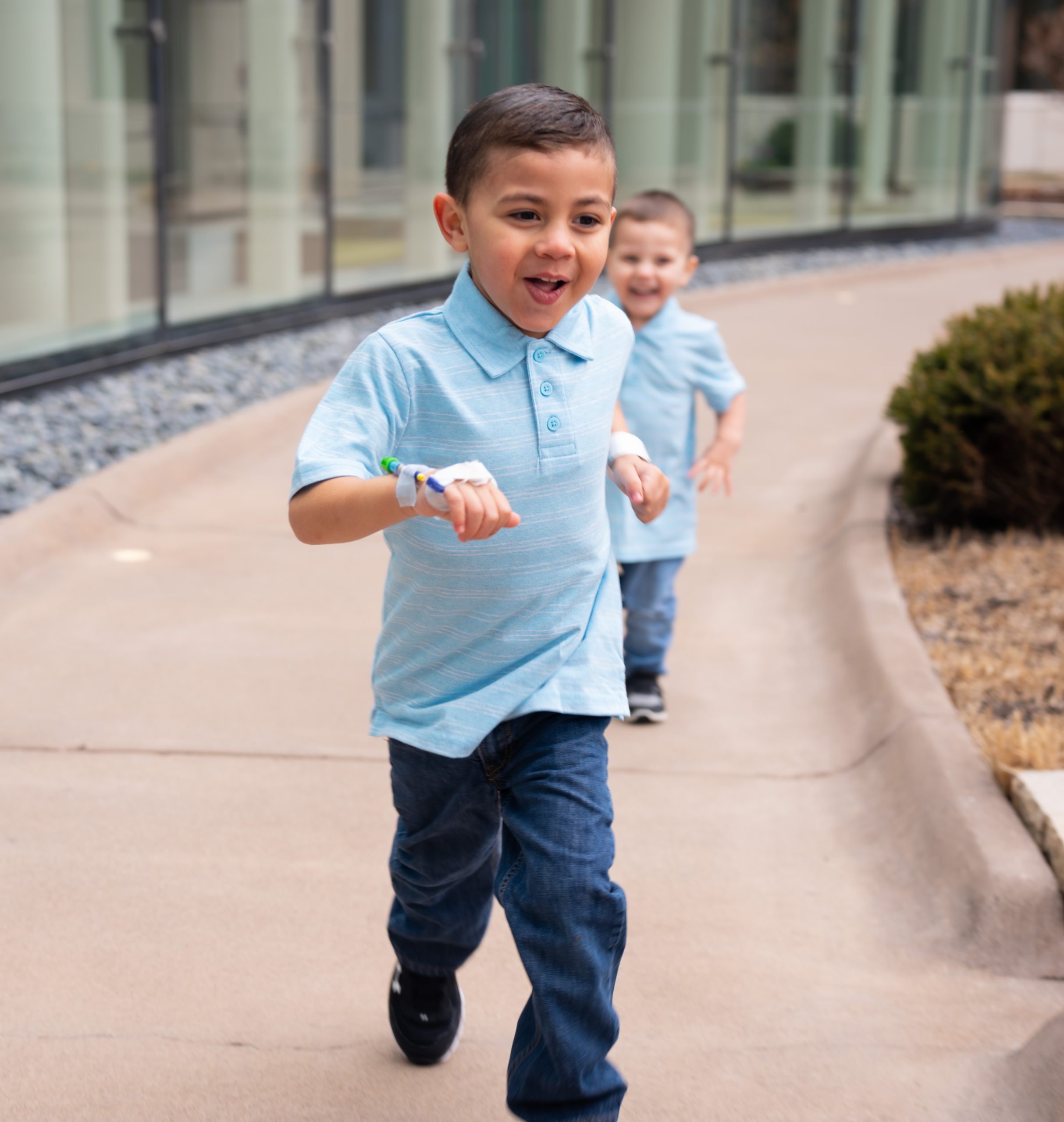 Ethan and his brother, Kayden, run on the sidewalk during their photo session