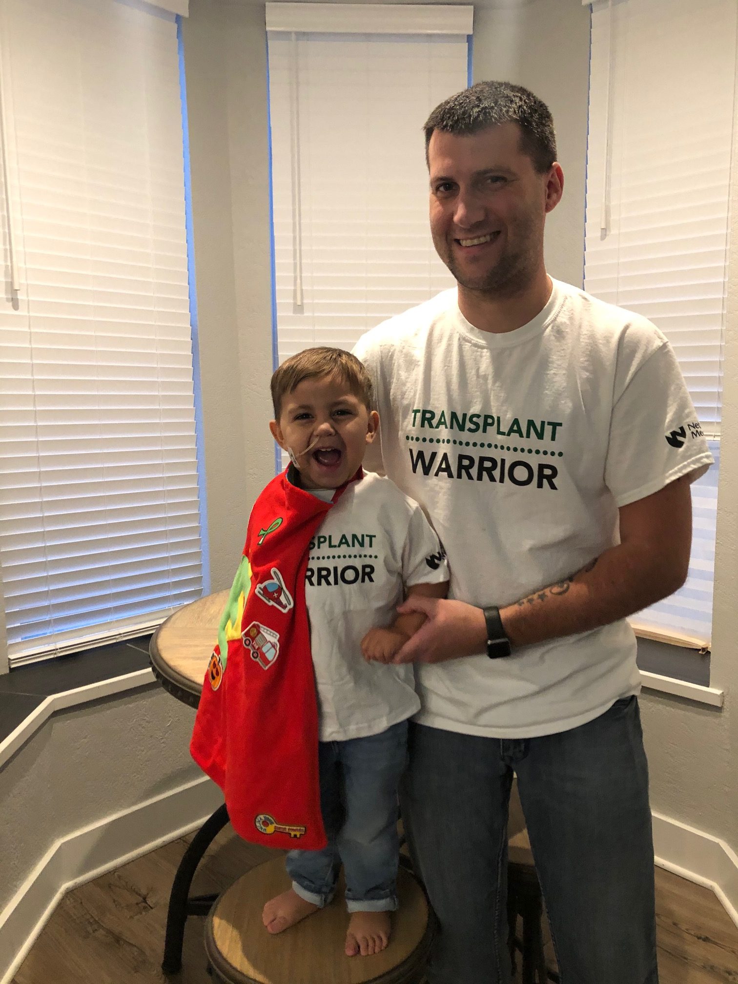 Ethan and his dad Zac poses with TRANSPLANT WARRIOR T-shirts. Zac donated a kidney to Ethan.