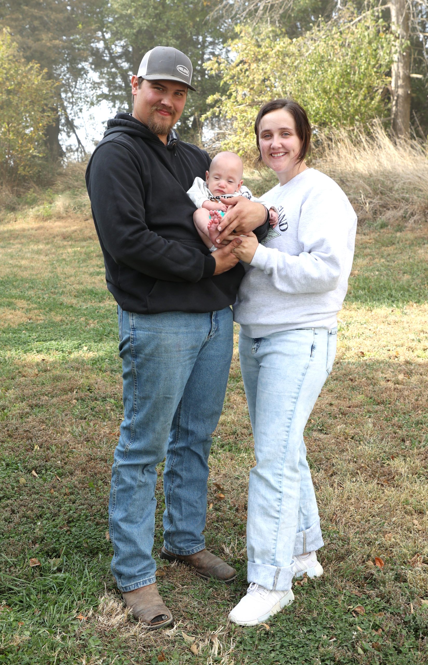 Couy and Taylor Johnson stand holding baby Thayne